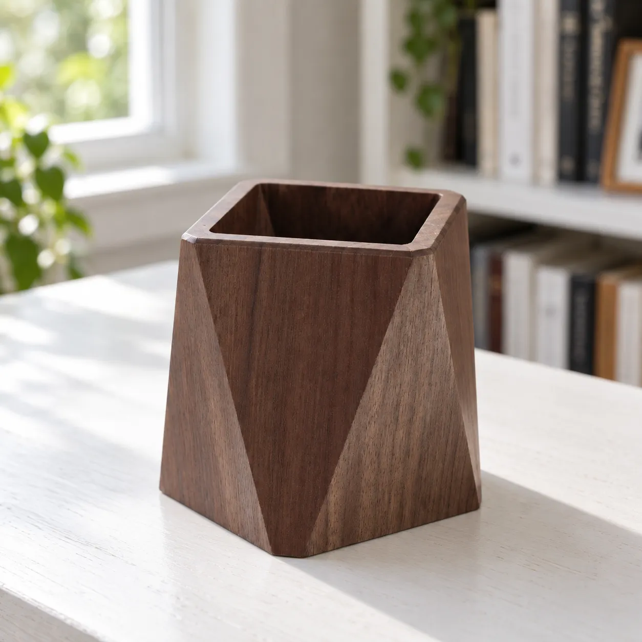 Faceted walnut pen cup, empty on a writing desk